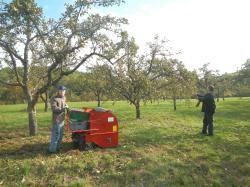 Mitarbeiter des Freundeskreises Mensch e.V. bei der Apfelernte mit einer PLENUM-geförderten Obstauflesemaschine auf der Streuobstwiese